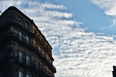 Low angle view of building against cloudy sky