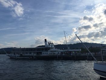 Boats moored at harbor against sky