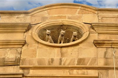 Low angle view of sculpture on building against sky