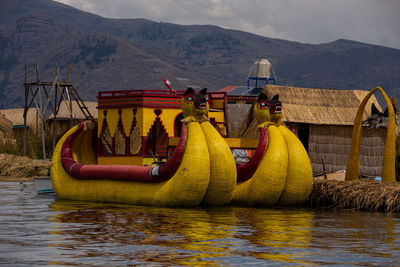 Boats in lake against mountains