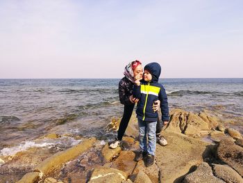 Full length of rock on beach against sky