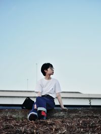 Full length of woman sitting on field against sky