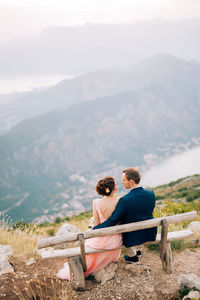 Rear view of couple sitting on bench