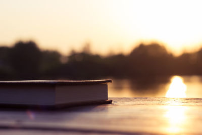 Close-up of books on table against sky during sunset