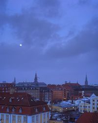 Buildings in city against cloudy sky