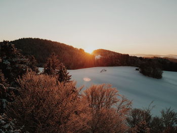 Scenic view of lake against clear sky during sunset