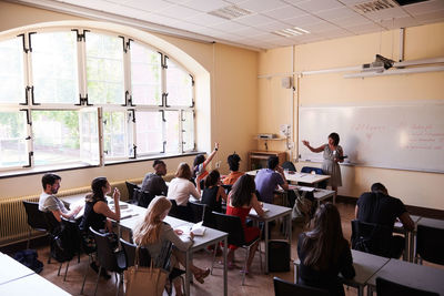 Female teacher asking questions to students in language school