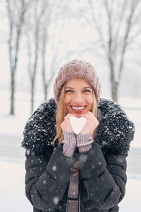 Portrait of smiling woman with snow during winter