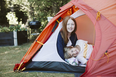 Brother and sister in tent in backyard