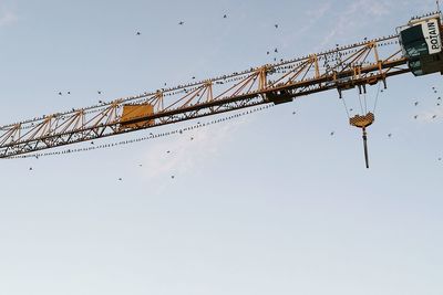 Low angle view of crane against clear sky