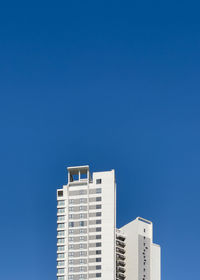 Low angle view of buildings against clear blue sky