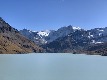 Scenic view of snowcapped mountains against blue sky