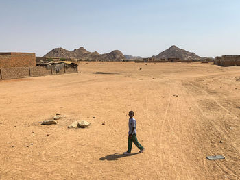 Full length of man standing on desert against sky