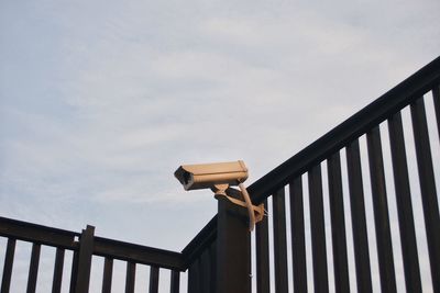 Low angle view of wooden railing against sky