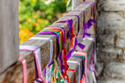 Close-up of multi colored ribbons tied on railing