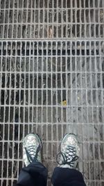 Low section of man standing on tiled floor