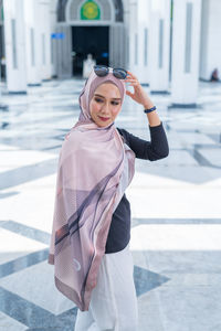 Portrait of young woman standing in city
