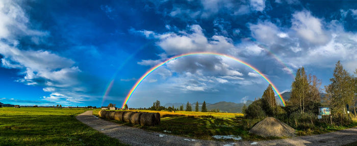 Scenic view of rainbow over land against sky