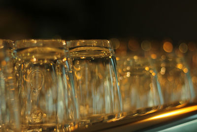 Close-up of wine glasses in row