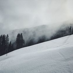 Snow covered landscape against sky