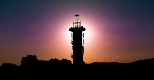 Low angle view of silhouette lookout tower against clear sky at dusk