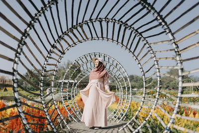 Full length of woman standing against built structure