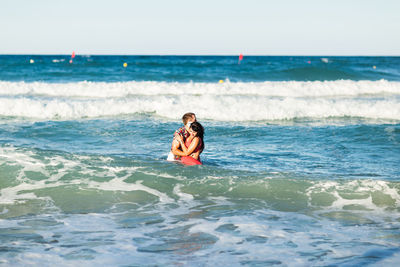 Person in sea against sky