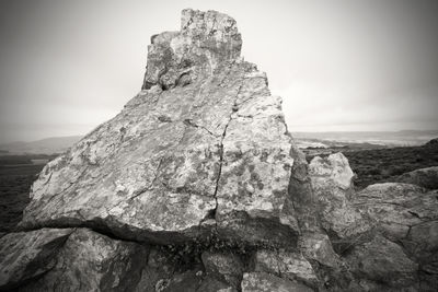 Rock formation on cliff against sky