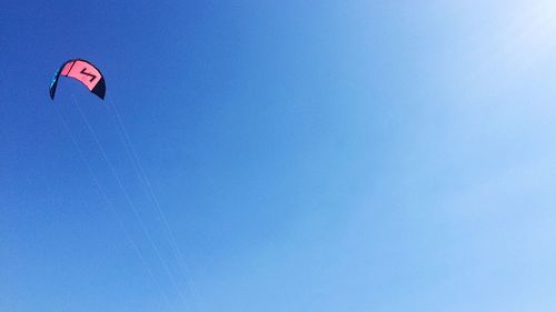 Low angle view of kite flying against clear blue sky