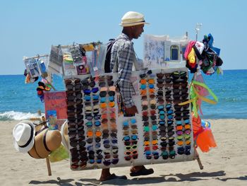 Rear view of people on beach against clear sky