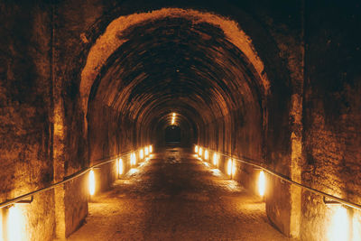 Rear view of empty illuminated tunnel