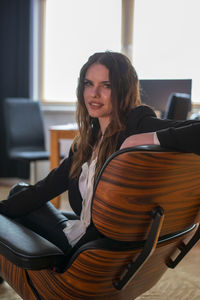 Portrait of smiling woman sitting on chair