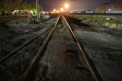 Illuminated railroad tracks at night