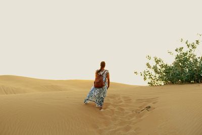 Rear view of woman on sand dune