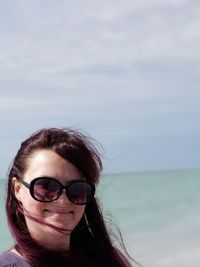 Portrait of smiling young woman against sea