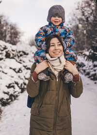 Portrait of smiling boy standing on snow