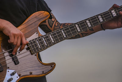 Midsection of man playing guitar