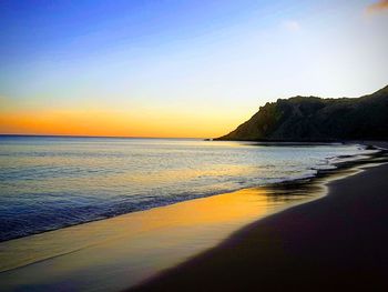 Scenic view of sea against clear sky at sunset