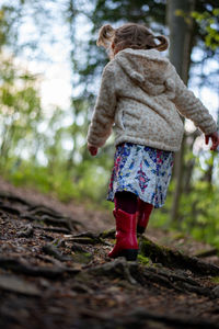 Rear view of woman walking in forest