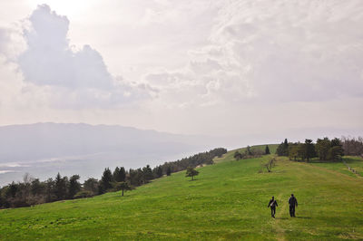 Scenic view of grassy field against cloudy sky