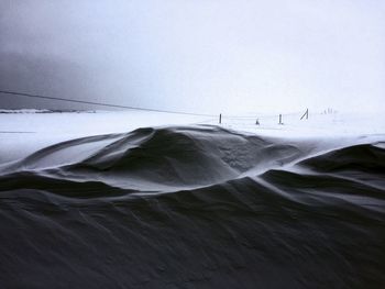 Scenic view of snow covered land against sky