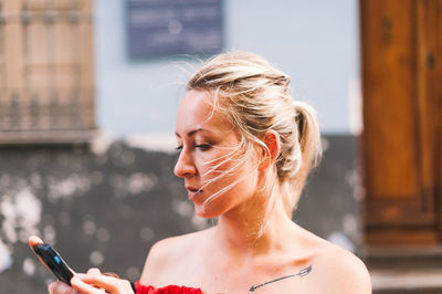 Portrait of young woman using mobile phone