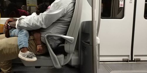 Low section of woman sitting in train