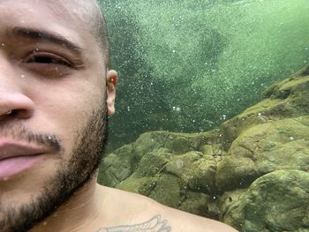 Close-up portrait of young man underwater