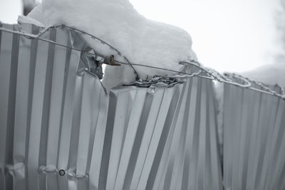 Broken fence. snow bent metal. collapse of fence. consequences of snowfall.