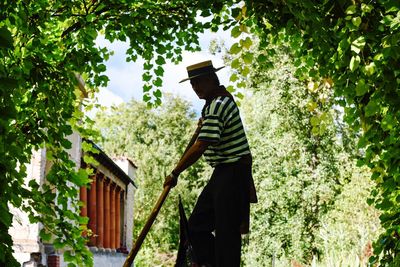 Man standing by plants in yard