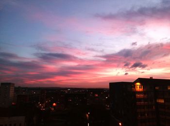 High section of silhouette buildings against dramatic sky