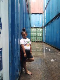 Full length portrait of boy standing against building