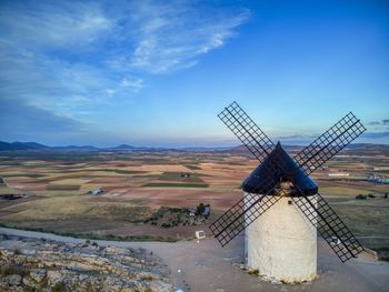 Traditional windmill on landscape against sky