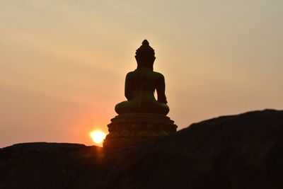 Low angle view of silhouette statue against sky during sunset